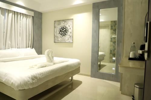 インドールにあるHotel Grand Girdharのベッドルーム1室(ベッド1台付)、バスルーム(鏡付)