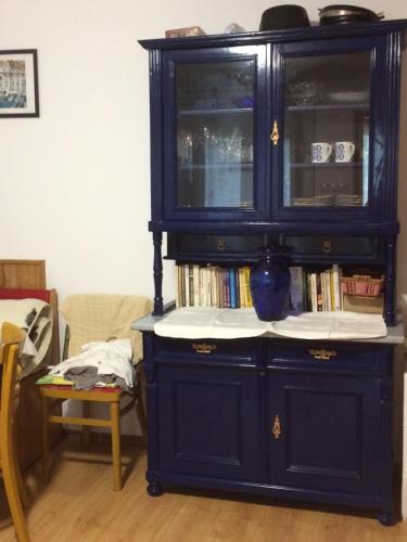 a dark blue hutch with a vase in it at SUNSHINE house in Orfű