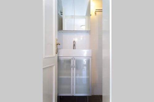 a bathroom with white cabinets and a sink at BougainvillaStudio in Cesme