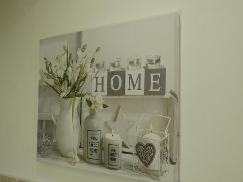 a shelf with vases and a home sign on it at La Gariotte in Esclauzels