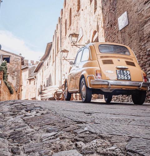 an old car parked on a street next to a building at Antica Torre del Borgo in Certaldo