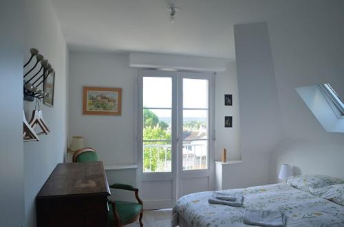 une chambre avec un lit, un bureau et une fenêtre dans l'établissement Appartement des remparts, à Guérande