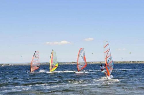 un grupo de personas haciendo windsurf en el océano en Barcaresa-LA PERLE VUE MER PIEDS DANS L'EAU CLIM WIFI, en Port Leucate