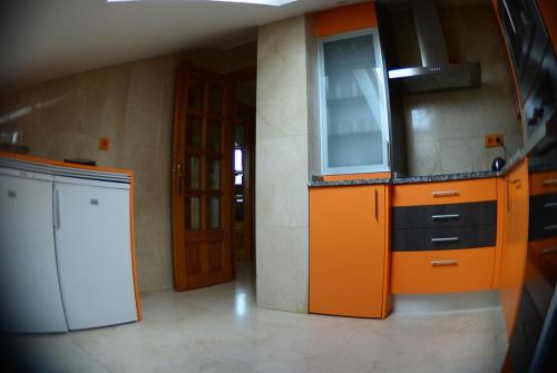 a kitchen with orange cabinets and a white appliance at Apartamento El Desván in Pedraza-Segovia