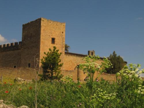 a large brick building in the middle of a field at Apartamento El Desván in Pedraza-Segovia