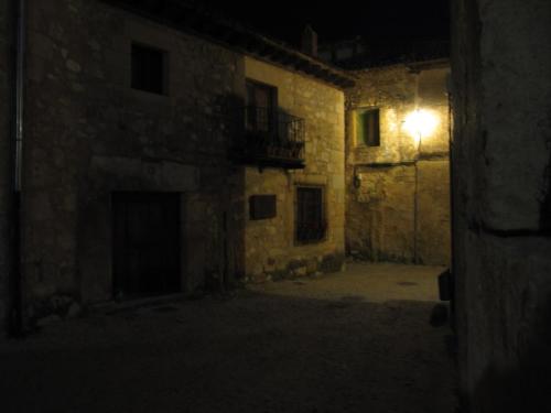 an empty alley at night with a light on a building at Apartamento El Desván in Pedraza-Segovia