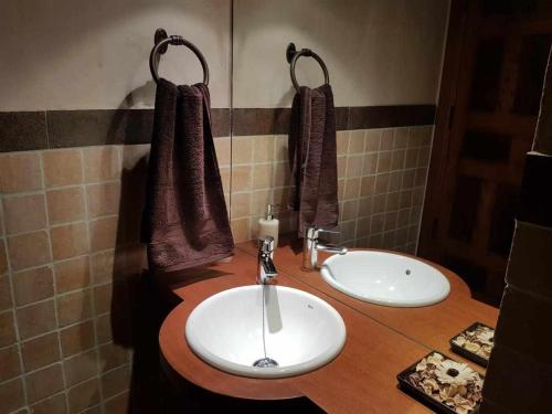 a bathroom with two sinks and towels on a counter at La casa de Don in Pedraza-Segovia