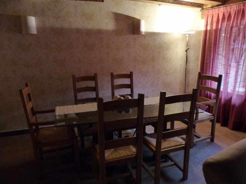a dining room with a wooden table and chairs at La casa de Don in Pedraza-Segovia