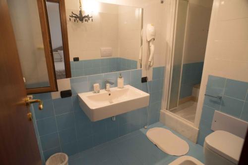 アシェーアにあるResidenza Lombardiの青いタイル張りのバスルーム(洗面台、トイレ付)