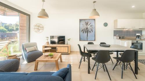 une cuisine et un salon avec une table et des chaises dans l'établissement Villa Spacieuse avec Jacuzzi Privatif, à Sarlat-la-Canéda