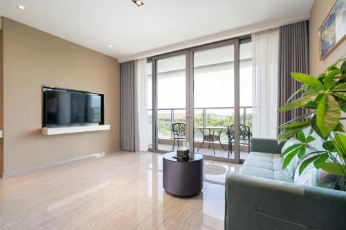 a living room with a couch and a tv at Van-Pretty Residence Haitang Bay Sanya in Sanya
