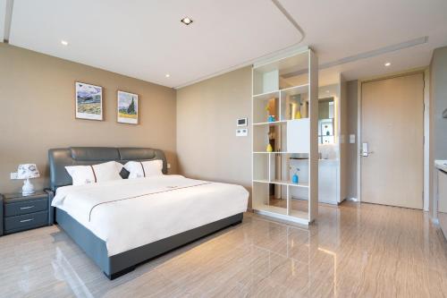 a bedroom with a bed and a book shelf at Van-Pretty Residence Haitang Bay Sanya in Sanya