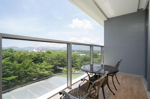 a balcony with a table and chairs and a large window at Van-Pretty Residence Haitang Bay Sanya in Sanya