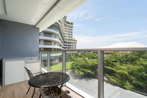 a balcony with a table and chairs and a building at Van-Pretty Residence Haitang Bay Sanya in Sanya
