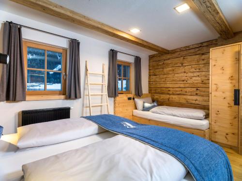 um quarto com 2 camas e uma parede de madeira em Hofchalet Berg - Örlerhof em Prateria
