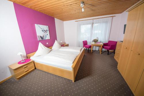 a bedroom with a bed and a table and chairs at Gästehaus-Weingut Loersch in Leiwen