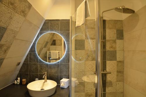 a bathroom with a sink and a shower with a mirror at Villa Augeval Hôtel de charme & Spa in Deauville