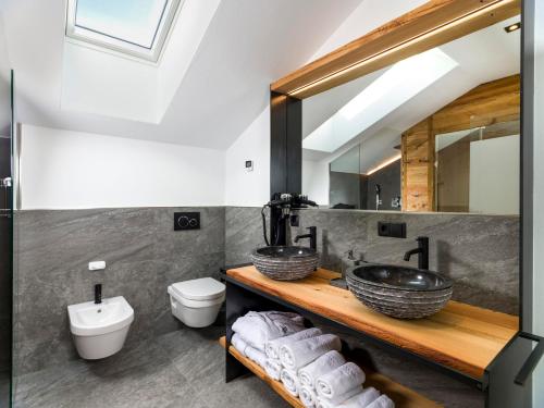 a bathroom with a sink and a toilet and a mirror at Hofchalet Alm - Örlerhof in Prateria