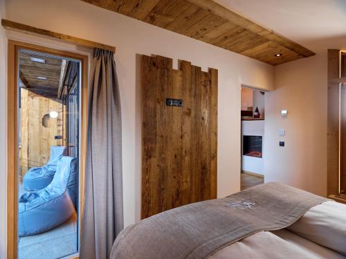 um quarto com uma cama e uma porta de vidro deslizante em Hofchalet Heu - Örlerhof em Prateria