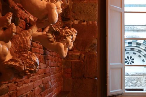 a wall with statues of women on a brick wall at L'antica Bifore in Lucca
