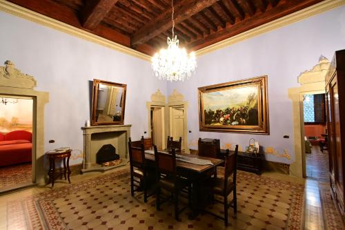 una sala da pranzo con tavolo e lampadario pendente di L'antica Bifore a Lucca