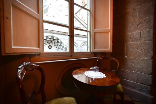 a table and two chairs in front of a window at L'antica Bifore in Lucca