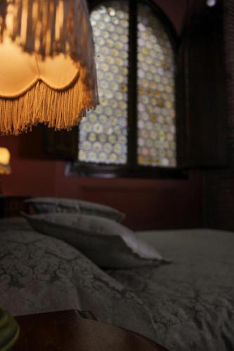 a bedroom with a bed with a window and a chandelier at L'antica Bifore in Lucca