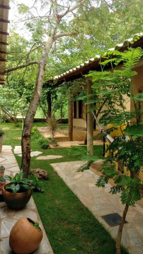 a garden with a tree and a building at Chalé Juliet in Pirenópolis