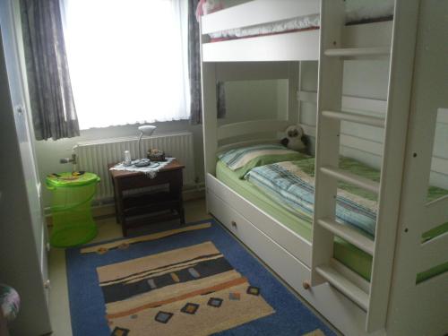 a childs bedroom with a bunk bed and a table at Haus Neuville in Medendorf, ruhige Lage in Bullange