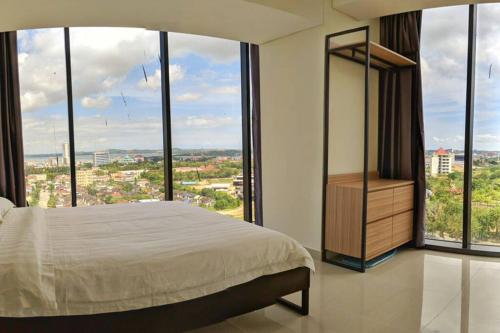 a bedroom with a bed and large windows at lovina 1115 at Pollux Meisterstadt in Batam Center