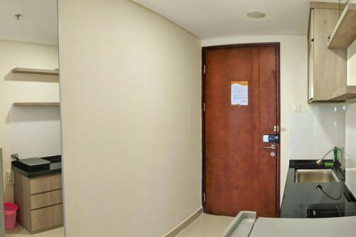 a kitchen with a wooden door in a room at lovina 1115 at Pollux Meisterstadt in Batam Center