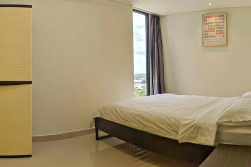 a bedroom with a bed and a large window at lovina 1115 at Pollux Meisterstadt in Batam Center