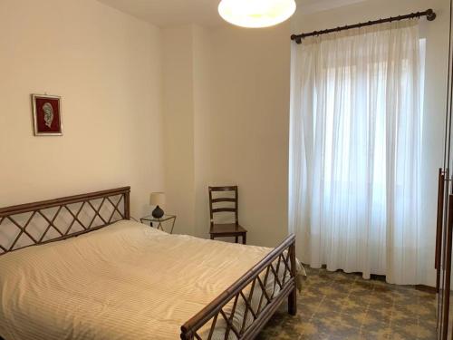 een slaapkamer met een bed en een groot raam bij Casa Lauretana in Loreto