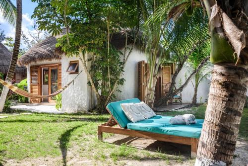 a couch in front of a house with a tree at Casa Blanca in Holbox Island