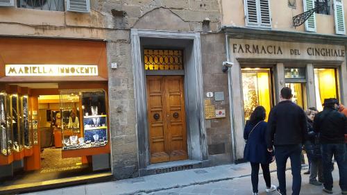 a group of people walking down a street in front of shops at Appartamento Signoria in Florence