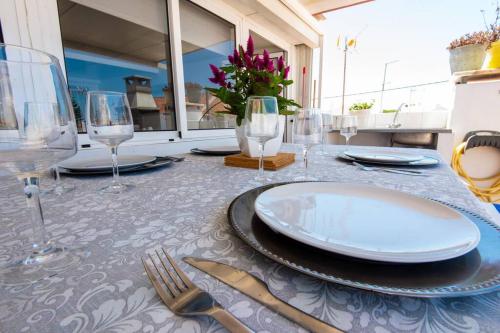 a table with plates and wine glasses on it at GreenEscapes I in Porto Covo
