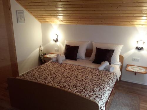 a bedroom with a large bed and two lamps at Lake House 1 in Plitvička Jezera