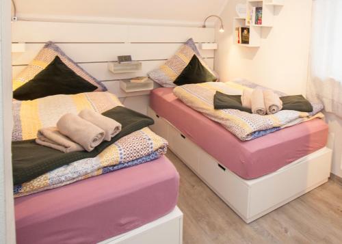 2 Betten in einem Zimmer mit Handtüchern darauf in der Unterkunft Blumeninsel in Horumersiel