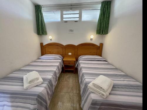2 Betten in einem Zimmer mit grünen Vorhängen in der Unterkunft Seaview Friendly Holiday Home 9 in Playa del Ingles