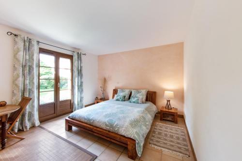 a bedroom with a bed and a window at Les Prunelliers in Rambouillet