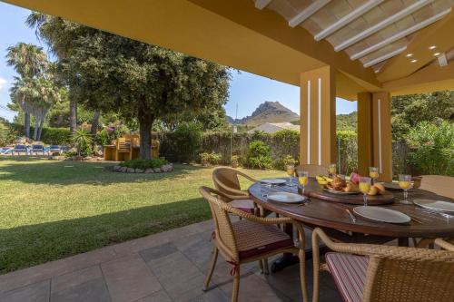 Un comedor al aire libre con mesa y sillas. en Villa Formosa, en Cala de Sant Vicent