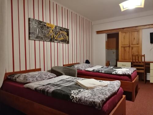 a bedroom with two beds and a picture of a bicycle on the wall at Penzion Na Kopečku in Česká Lípa