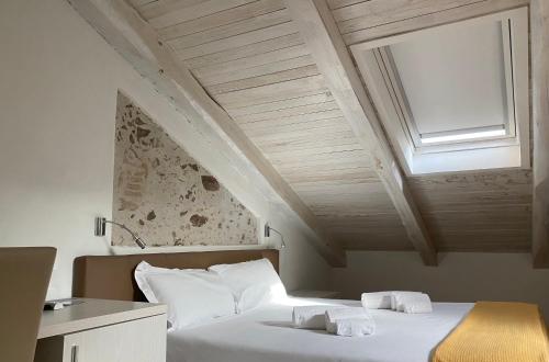 a bedroom with a white bed with a skylight at B&B Cerasarella in Vibo Valentia