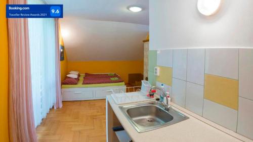 a small kitchen with a sink and a bed at Apartman Üde in Bánd