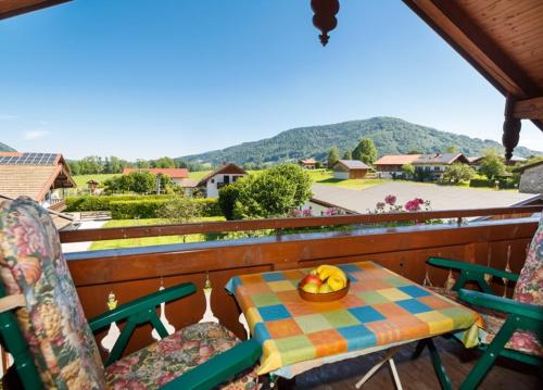 a table and chairs with a bowl of bananas on a balcony at Ferienwohnung Heidi Steinbacher in Ruhpolding