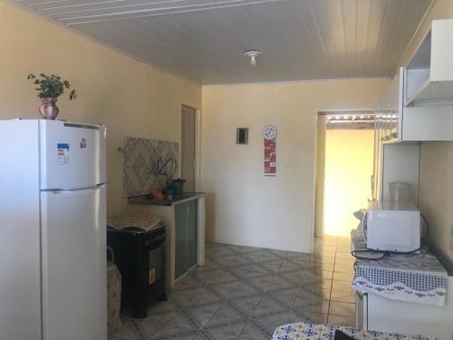 een keuken met een witte koelkast in de kamer bij Casa na Praia de Barra do Gil in Vera Cruz de Itaparica