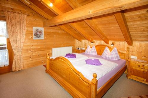 a bedroom with a large bed in a log cabin at Ferienwohnung Heidi Steinbacher in Ruhpolding