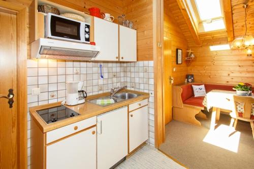 a small kitchen with a sink and a microwave at Ferienwohnung Heidi Steinbacher in Ruhpolding