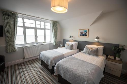 a bedroom with two beds and a window at The Kingswood Hotel in Sidmouth