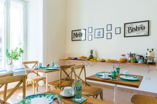 a dining room with two tables and chairs and a dining roomestamp at La Gatta Cenerentola Rooms in Naples